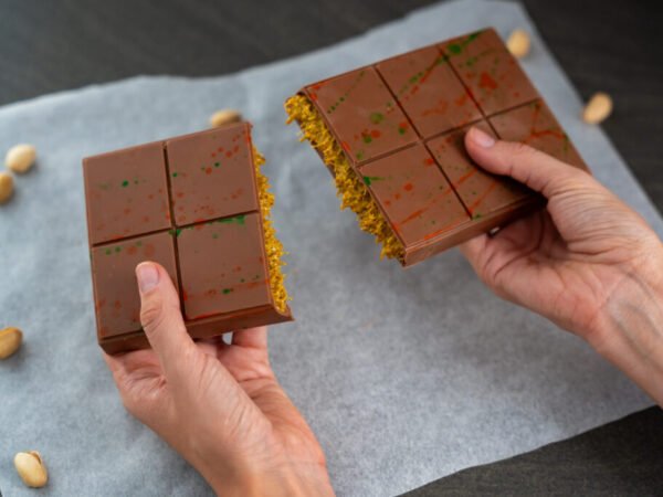 Trend Dubai chocolate with pistachio paste and kataifi dough in woman hands. Confectionery handmade sweets at home in the kitchen.