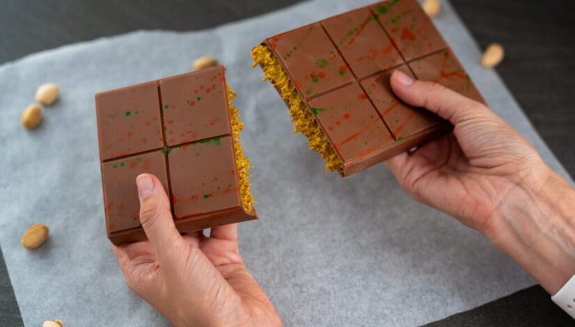 Trend Dubai chocolate with pistachio paste and kataifi dough in woman hands. Confectionery handmade sweets at home in the kitchen.