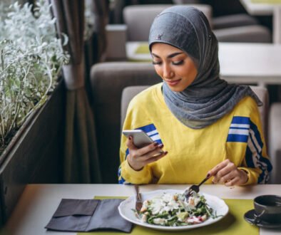 Arabian woman in hijab inside a cafe eating salad