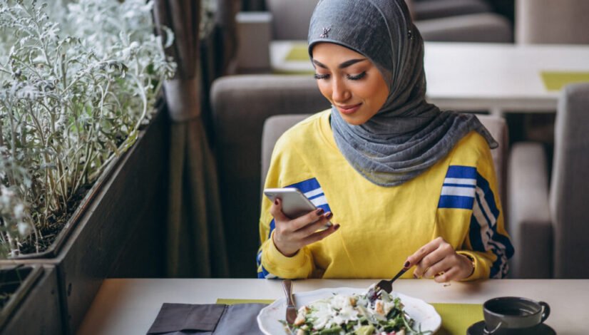 Arabian woman in hijab inside a cafe eating salad