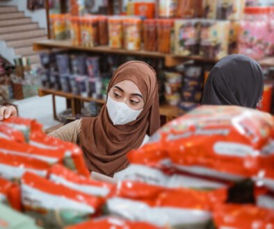 Muslim girl in mask choosing items while shopping in store