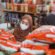 Muslim girl in mask choosing items while shopping in store