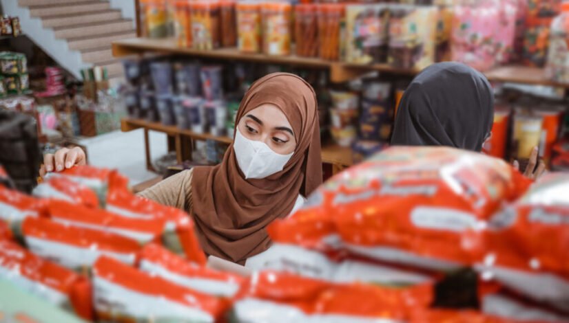 Muslim girl in mask choosing items while shopping in store